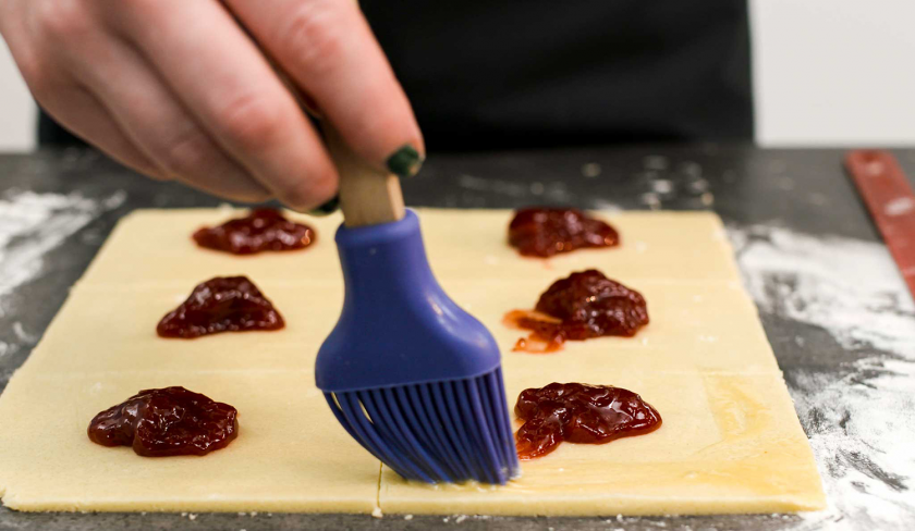 Der Teig für süße Knallbonbons wird mit Ei eingestrichen.