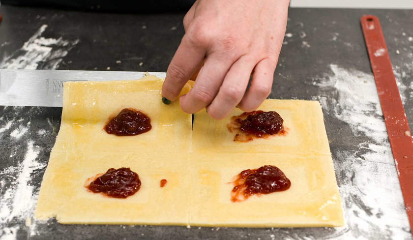 Der Teig für süße Knallbonbons wird über die Füllung gelegt.