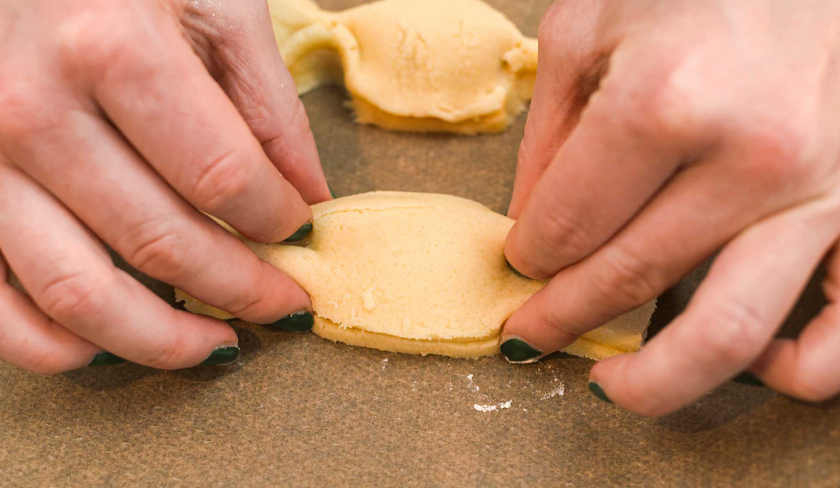 Die Teigränder der süßen Knallbonbons werden zusammengedrückt.
