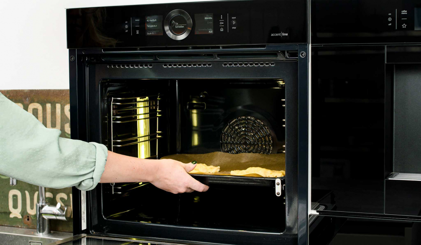 Ein Blech süße Knallbonbons wird in den Ofen geschoben.