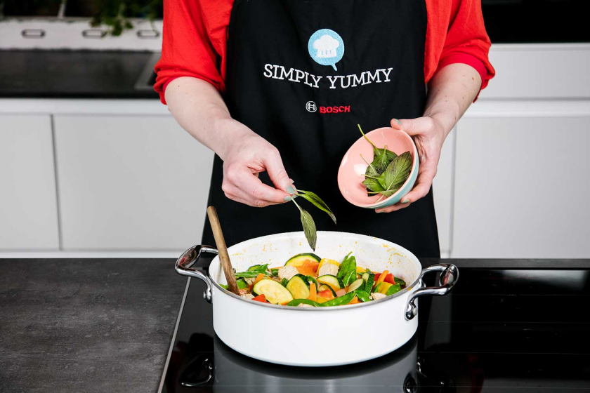 Dem Thai Curry wird Thai-Basilikum zugegeben,