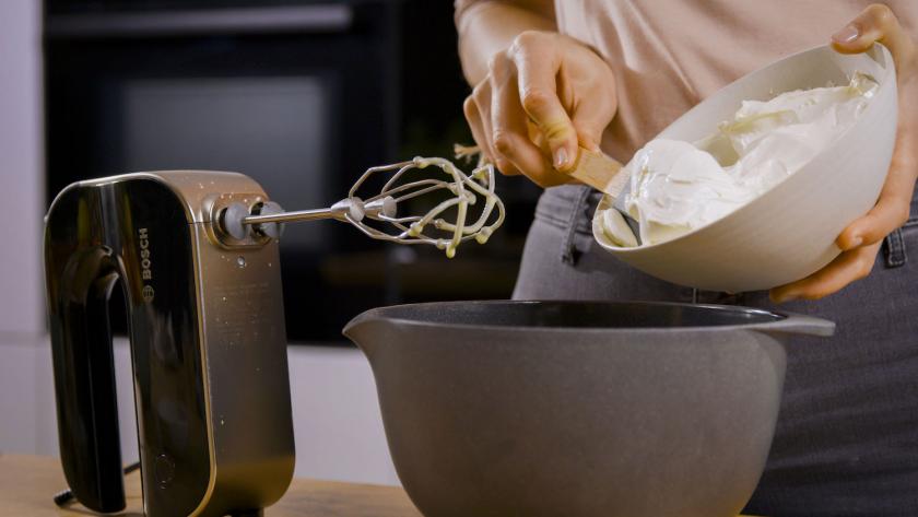Mascarpone wird in eine Rührschüssel gegeben, daneben ein Handrührgerät.