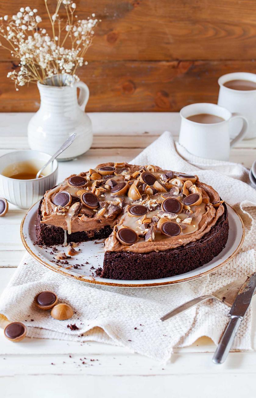 Toffifee-Torte angeschnitten auf einer Kuchenplatte.