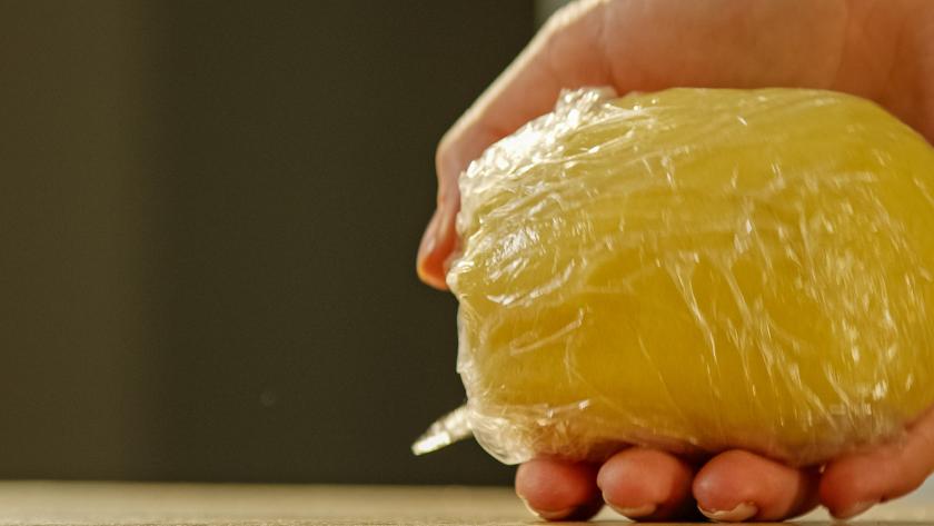 Teig wird in Folie eingeschlagen.