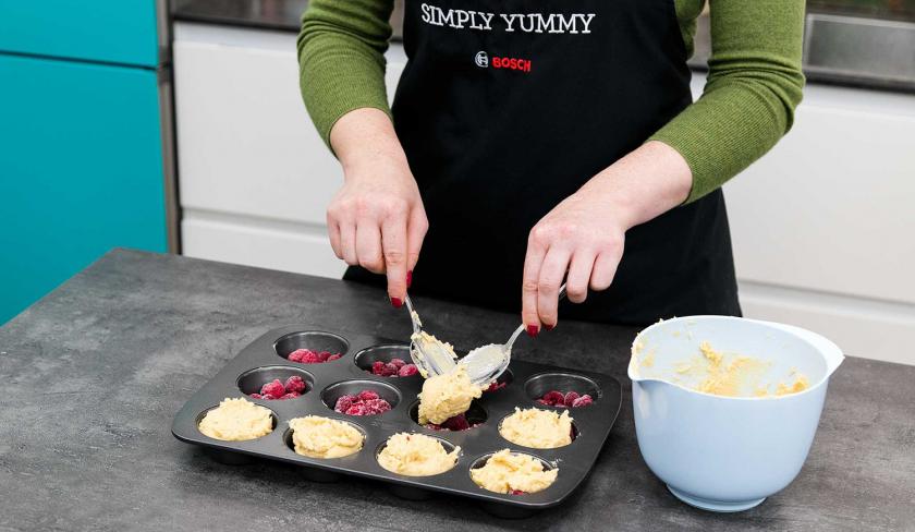Der Teig für die Upside Down Low Carb Muffins wird auf die Muffinmulden verteilt.