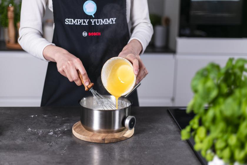 Eigelbmischung wird in heiße Milch eingerührt.