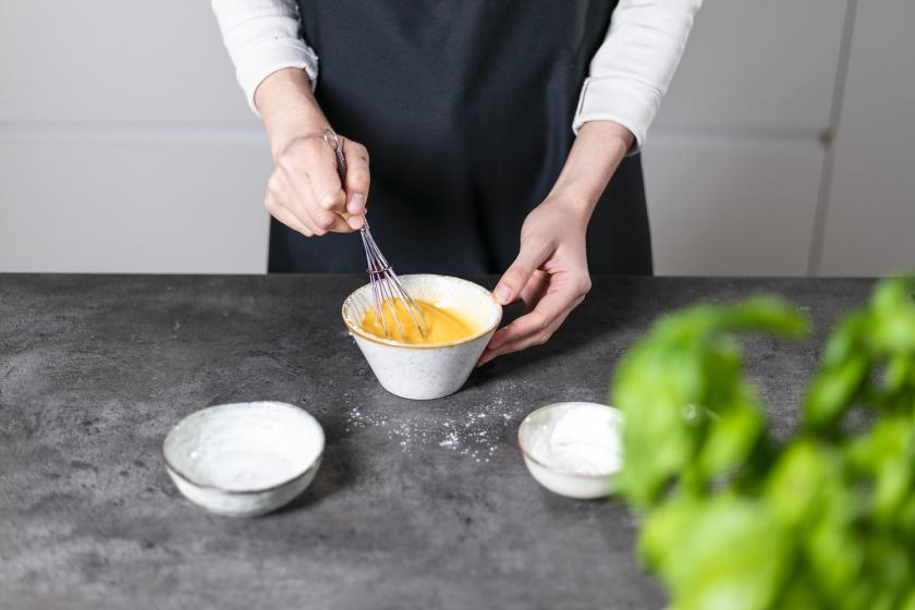 Eigelb und Zucker werden in einer kleinen Schale miteinander verrührt.