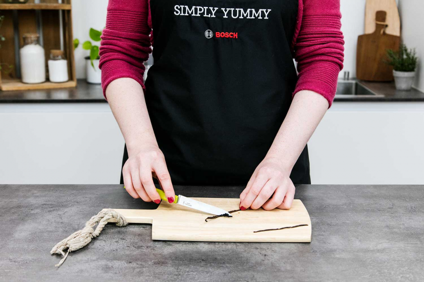 Für die Vanillesoße wird das Mark einer Vanilleschote ausgekratzt.