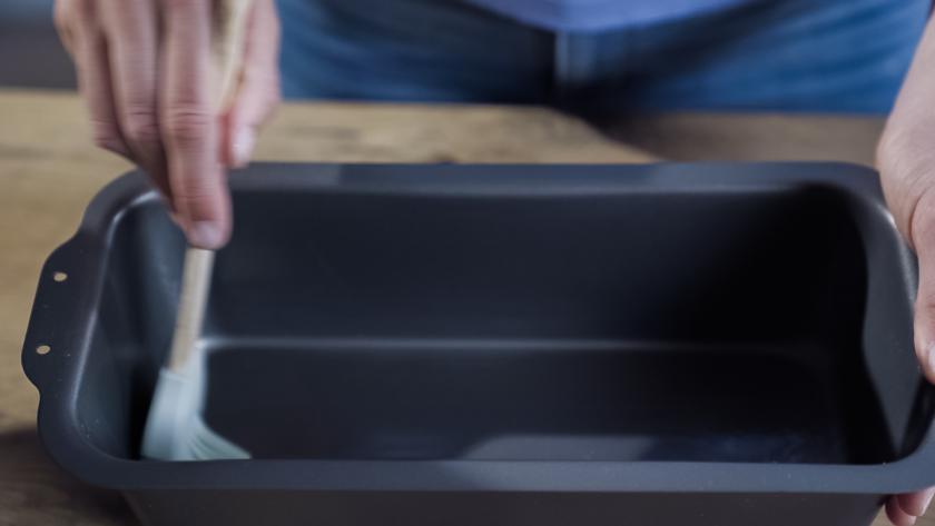 Eine Kastenform wird eingefettet.