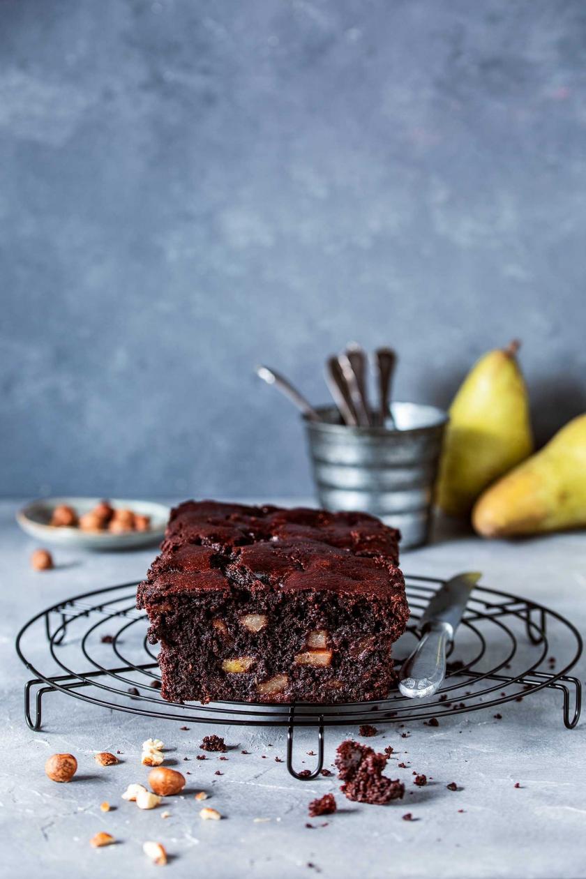 Veganer Birnenkuchen auf einem Kuchengitter mit angelegtem Messer.