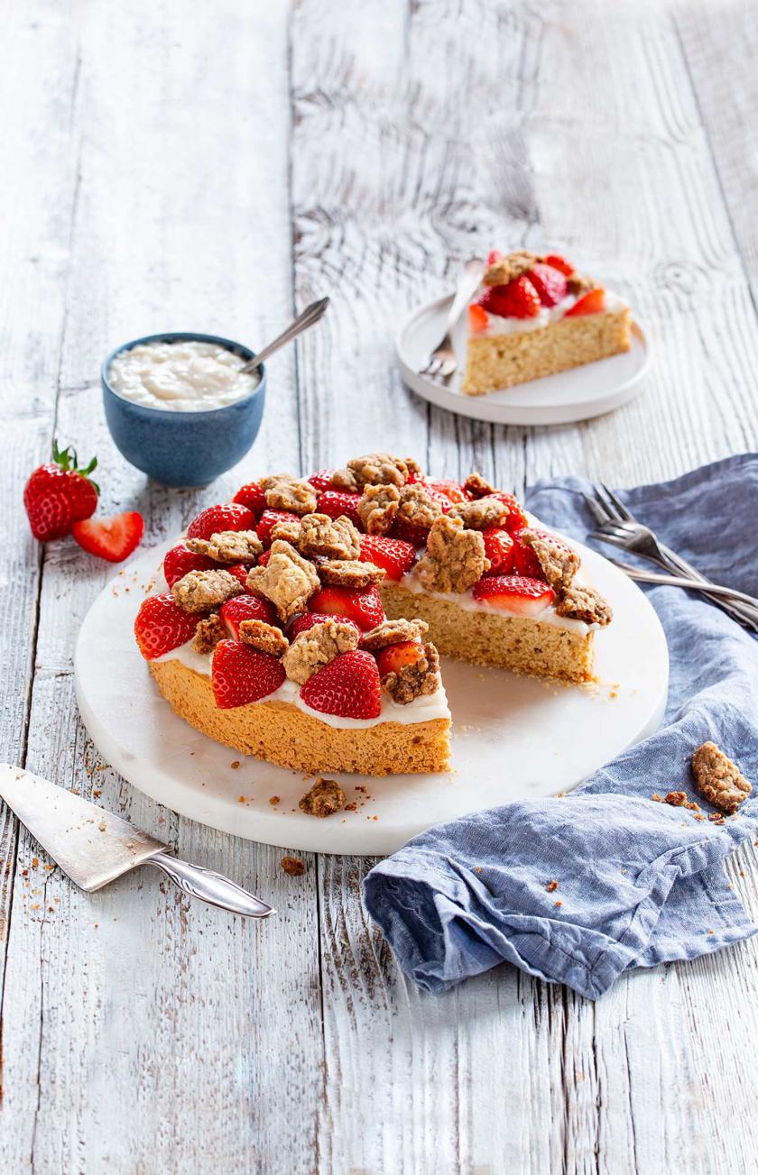 Veganer Erdbeerkuchen angeschnitten auf einem Kuchenteller.