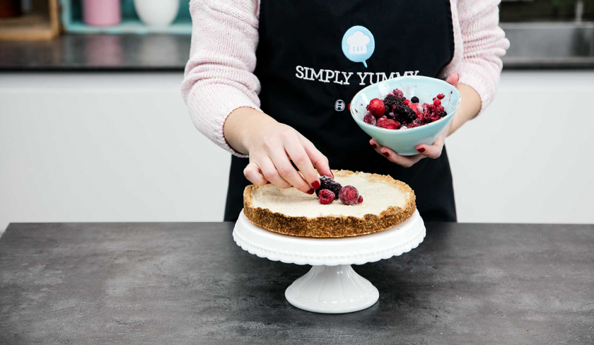 Der vegane Käsekuchen wird mit Beeren garniert.