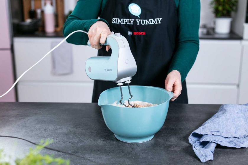 Der Teig für die Vollkornbrötchen wird mit einem Handmixer geknetet.