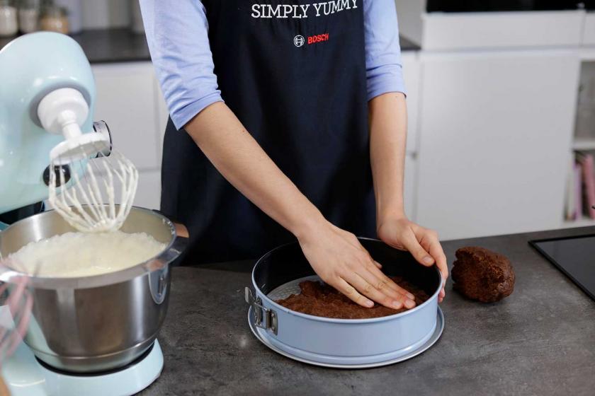 Der Teig für den weihnachtlichen Zupfkuchen wird in eine Springform gedrückt.
