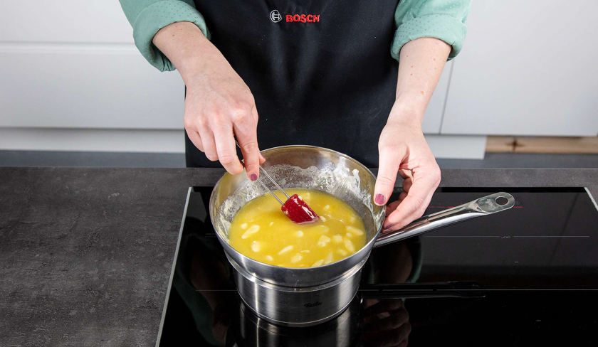 Für weiße Schoko-Kokos-Blondies wird weiße Schokolade in einem Wasserbad geschmolzen.