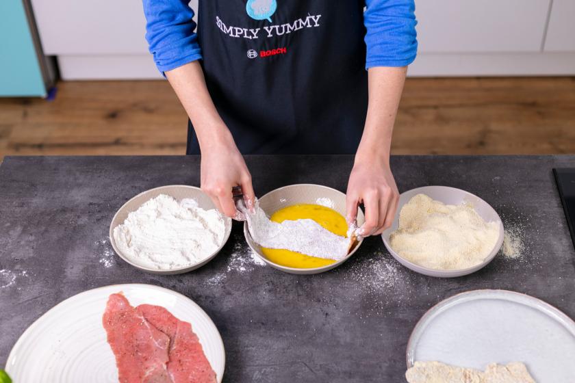 Wiener Schnitzel wird paniert.