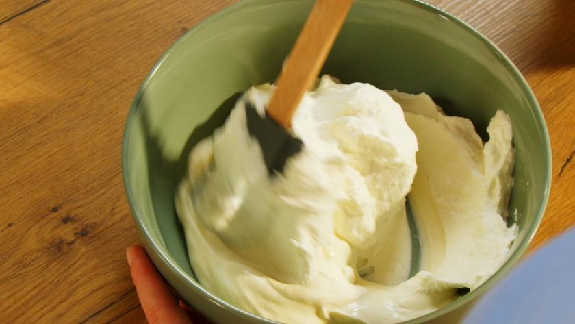 Sahne wird in einer Schüssel unter Schmand gehoben.