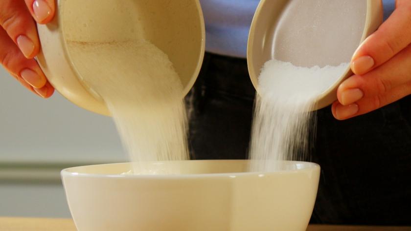 Zweierlei Zucker wird in eine Schale gegeben.