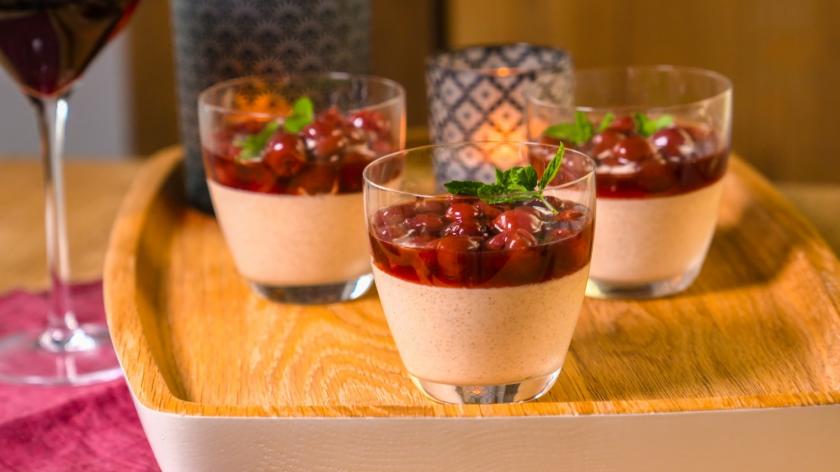 Zimtmousse mit Glühweinkirschen in einem Glas geschichtet.
