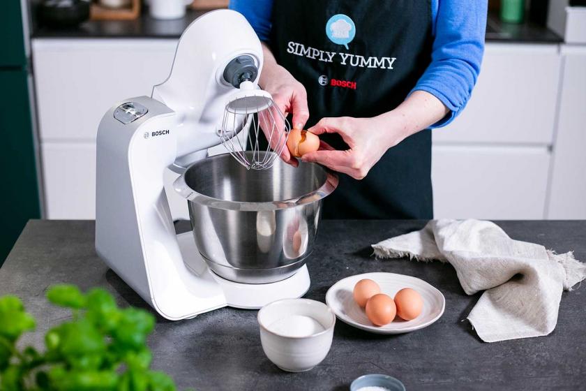 Eier werden in die Rührschüssel einer Küchenmaschine gegeben.
