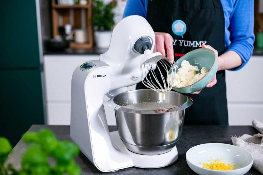 Frischkäse wird in die Rührschüssel einer Küchenmaschine gegeben.