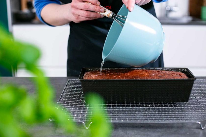 Die Tränke wird über den Zitronenkuchen mit Frischkäse verteilt.