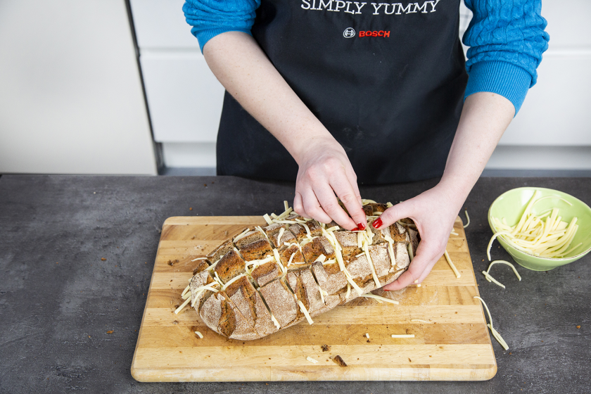 Für ein gefülltes Brot werden die Schnittflächen mit Käse gefüllt.