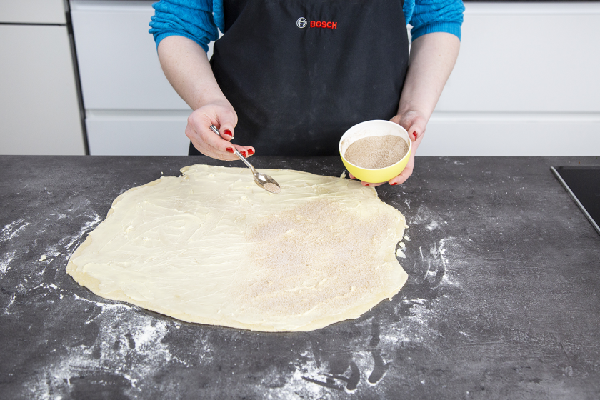 Der Teig für das Zupfbrot wird mit Zimtzucker bestreut.