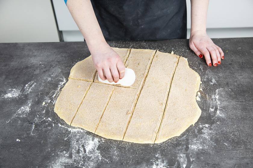 Der Teig für das Zupfbrot wird mit einer Teigkarte geschnitten.