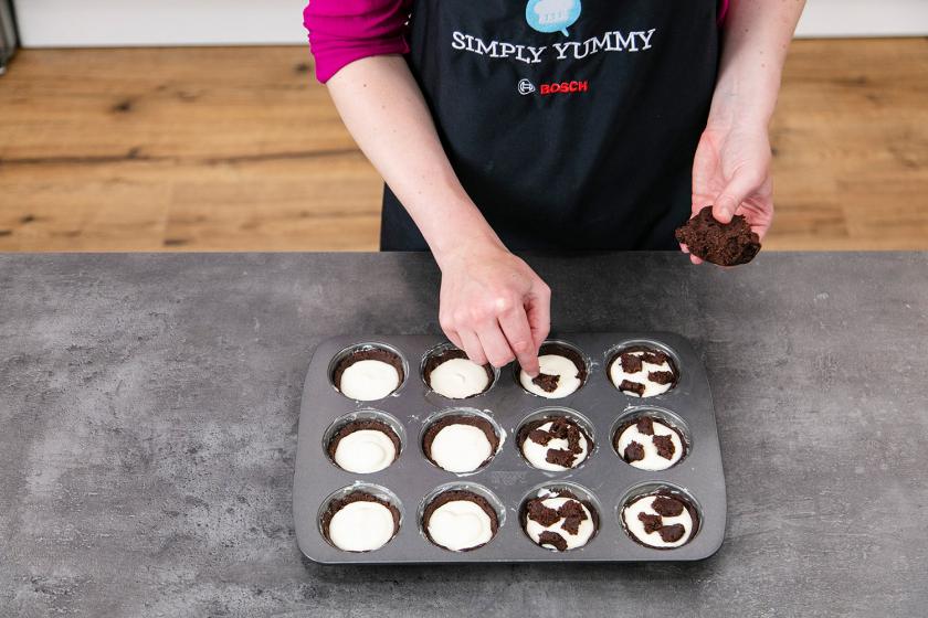 Dicke Streusel werden auf den Zupfkuchen Muffins verteilt.