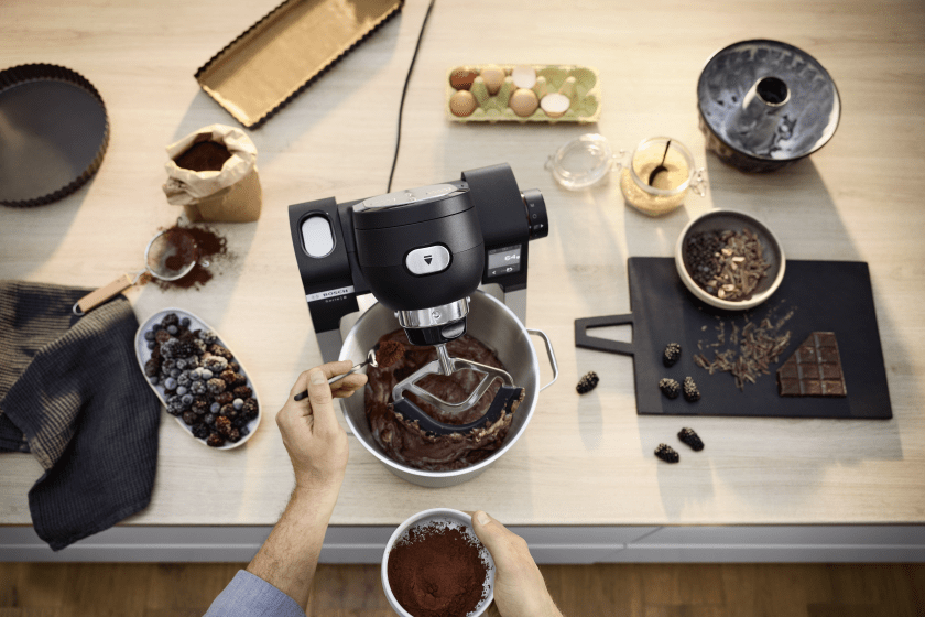 Küchenarbeitsplatte mit verschiedenem Backzubehör, es wird gerade ein Kuchen mit Schokolade zubereitet