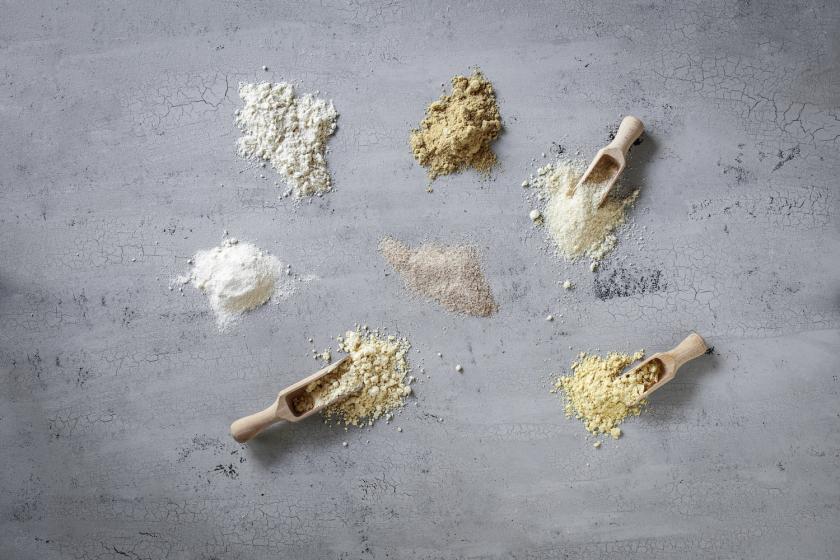 Verschiedene Mehlsorten auf einer Arbeitsfläche verteilt.