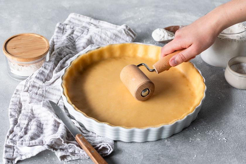 Quiche Teig wird in der Form ausgerollt